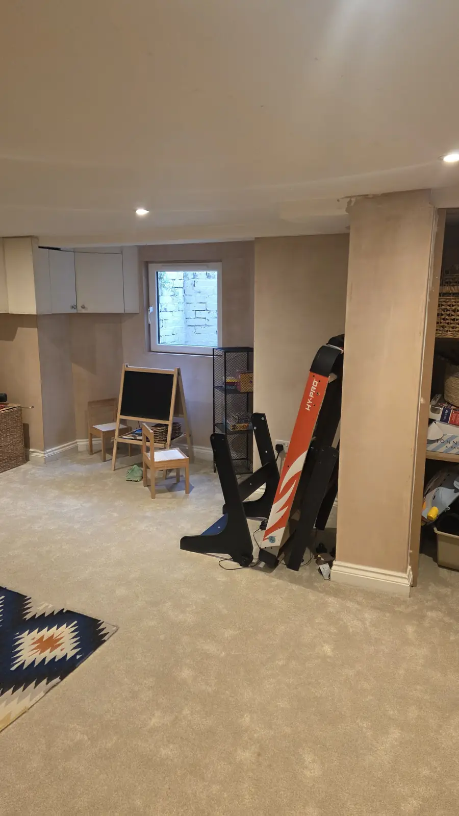 Finished basement with carpet, window and shelving back in place