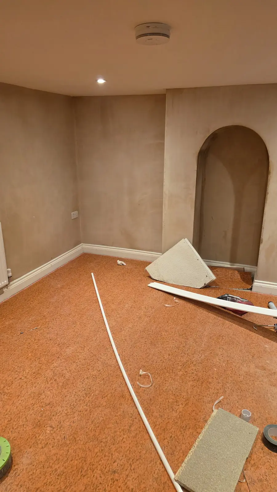 Replastered cellar walls and the rebuilt arched alcove before flooring