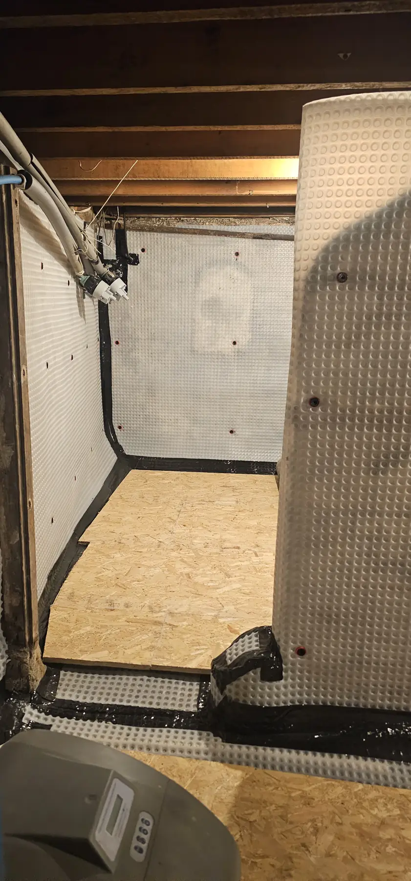 Membrane-lined alcove with boarded floor in the large basement