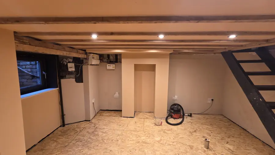 The cellar after plastering, with the new black staircase and window
