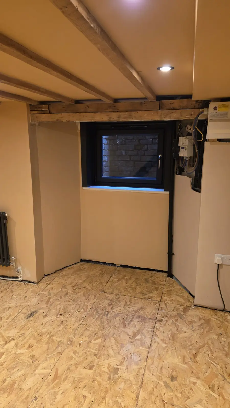 New anthracite window set into the cellar wall with the meters boxed in beside it