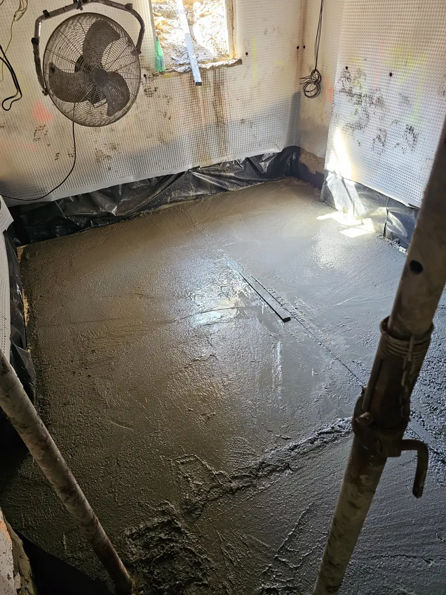 New concrete slab poured at the lower level with the membrane already on the walls