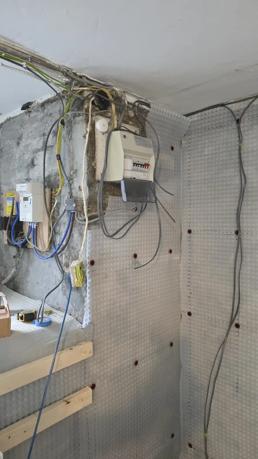 Cavity drain membrane fixed to the cellar walls around the consumer unit and meters