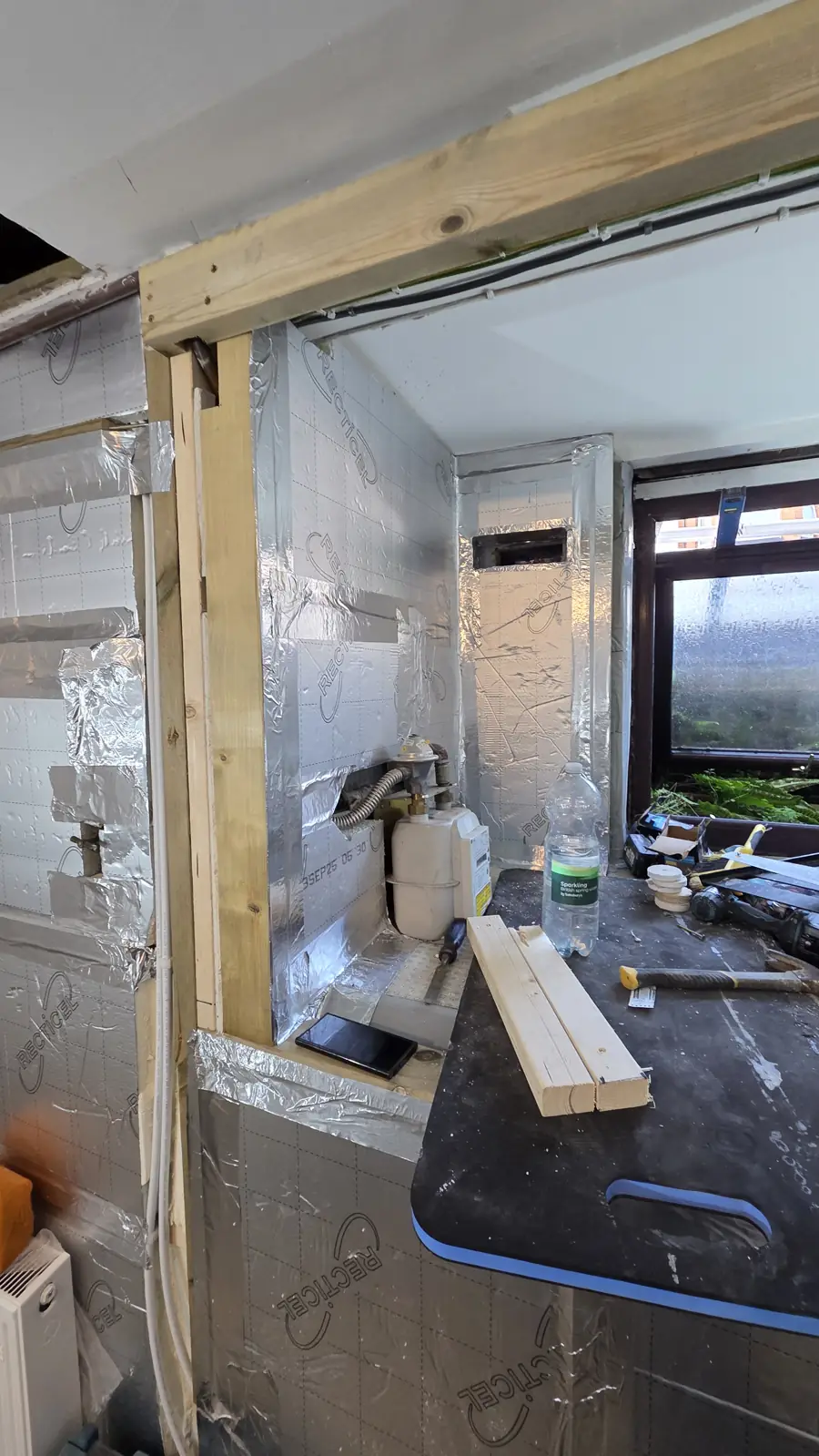 Insulation boards and timber framing around the new fire escape window opening