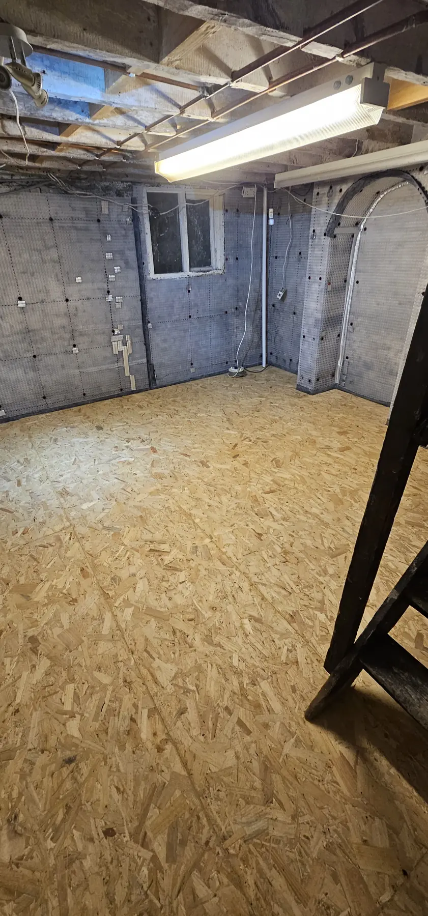 Cellar finished as dry storage: cavity drain membrane on the walls, OSB boarded floor and a sump in the corner