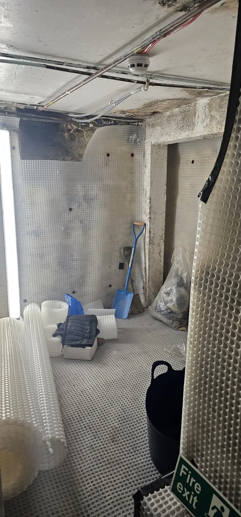 Black mould and damp staining on a cellar wall and ceiling before treatment, Kent